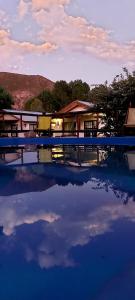 a swimming pool with two chairs and a house at Cabañas Terramaría de Potrerillos in Potrerillos