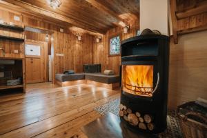 a living room with a fireplace in a log cabin at Koča Bistra - Velika planina in Stahovica