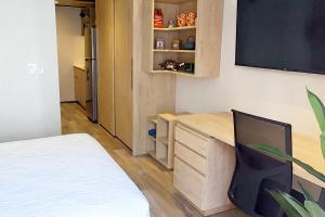 a bedroom with a desk and a bed in a room at Emerald Apt at Maho Beach in Maho Reef