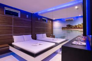 a bedroom with two beds and a table in it at Motel Fantasy 2 (Adult Only) in Contagem