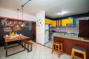 ブルマジーニョにあるHostel LAResのキッチン(黄色のキャビネット、テーブル、椅子付)