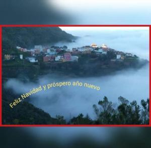 a picture of a town on a hill in the fog at Casa las montañas de Anaga in Las Lagunas