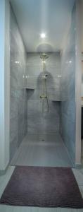 La salle de bains est pourvue d'une douche avec une porte en verre. dans l'établissement Gîte l'escapade 90, à Rougegoutte