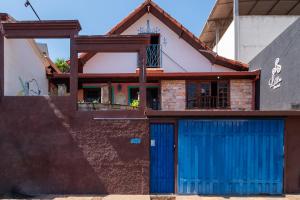 ブルマジーニョにあるHostel LAResの青いガレージドアが目の前にある家