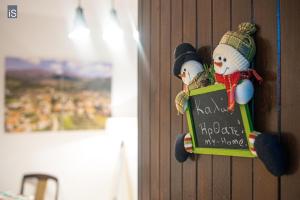 a sign with two snowmen on a wall at MY HOME in Áno Lekhónia