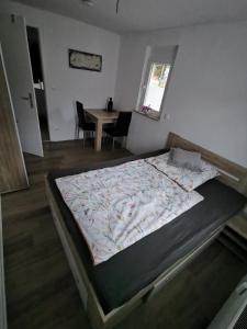 a large bed in a room with a table at Privatzimmer in ruhiger Lage in Heidenheim/ Steinheim am Albuch in Steinheim am Albuch