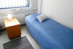 a bedroom with a blue bed and a night stand at Lähellä keskustaa in Kitee