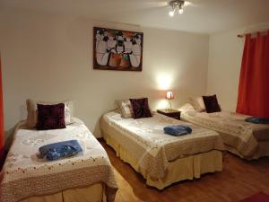 um quarto com duas camas e uma foto na parede em cabañas Te Pito Kura em Hanga Roa
