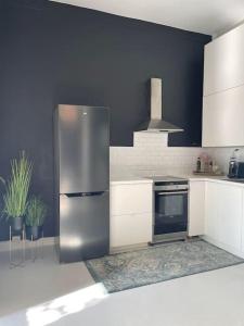 a kitchen with a stainless steel refrigerator and a stove at Fancy apartment by Royal Palace in Oslo