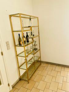 een kamer met een glazen plank met flessen erop bij Villa luxe 