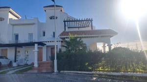 Un bâtiment blanc avec une tour en haut dans l'établissement villa star hill Tanger, à Tanger