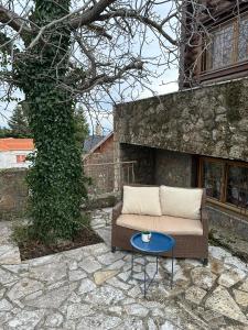 a couch and a table on a stone patio at Oreias Chalet in Ano Trikala