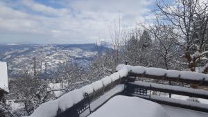 a bench covered in snow on top of a mountain at Oreias Chalet in Ano Trikala