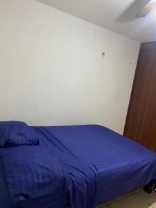 a bedroom with a bed with a blue comforter at Hermoso Departamento Minimalista Acogedor En Coto in Guadalajara