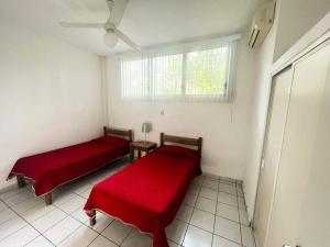 two beds in a room with a window at Suites Galván centro Colima, alberca, Wifi, parking in Colima +31 photos