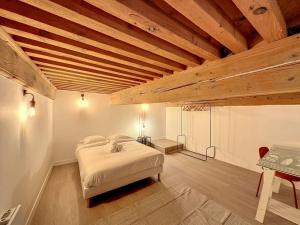 - une chambre avec un lit et un plafond en bois dans l'établissement Cosy appt, Croix rousse Duviard 2, à Lyon