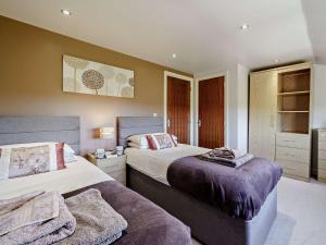 a bedroom with two beds with purple blankets at 2 Bed in Mellor FINCH in Blackburn