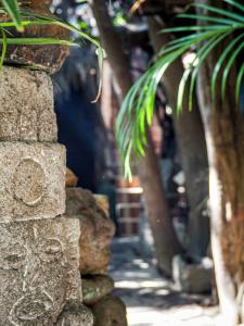 una pared de piedra con palmeras en el fondo en Hotel San Francisco en San Pedro La Laguna