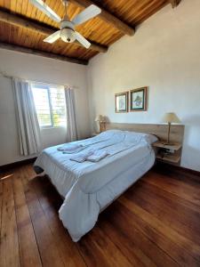 1 dormitorio con 1 cama grande y ventilador de techo en Pindó I en Concordia