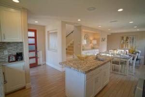 a kitchen with a counter top and a dining room at Steps from the Sand-Rooftop Spa-Incredible Views in Newport Beach