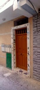 una entrada a un edificio con una puerta roja en Appartement meublé à Mdiq vue sur mer à 16 RL 2 Avenue KADI AYAD app 5 code postale 93200 la rue entre auto-école et dawajin al khayrat, en M'diq