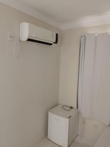 uma casa de banho branca com ar condicionado na parede em Hotel California em Goiânia