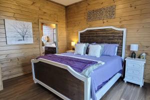 a bedroom with a large bed and a wooden wall at Serenity at Lake Haven in Dandridge