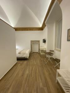 een slaapkamer met witte muren, een bed en een open haard bij Duomo Holiday in Napels
