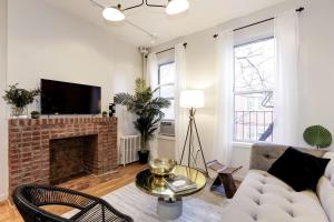 a living room with a couch and a fireplace at Apartment 129: Upper East Side in New York