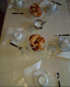 a table with plates of food and glasses on it at La Posada Encantada in Mar del Plata
