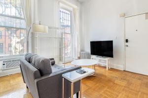 a living room with a couch and a tv at Apartment 1427: Fort Greene in Brooklyn
