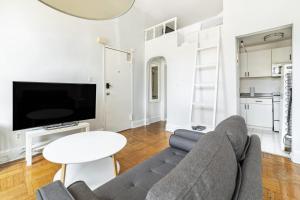 a living room with a couch and a tv and a table at Apartment 1427: Fort Greene in Brooklyn