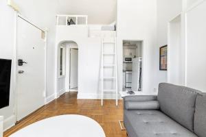 a living room with a couch and a ladder at Apartment 1427: Fort Greene in Brooklyn