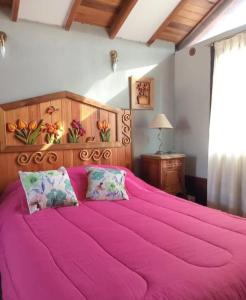 a bedroom with a large pink bed with two pillows at La Posada Encantada in Mar del Plata