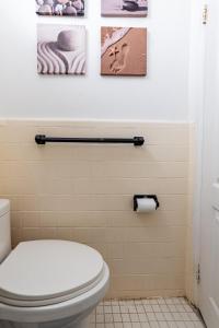 ブルックリンにあるApartment 1411: Fort Greeneのトイレ付きのバスルーム、壁に3枚の絵が飾られています。