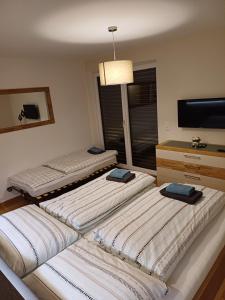 three beds in a room with a flat screen tv at Egon's Home - Urlauben in Top Lage in Sankt Jakob in Haus