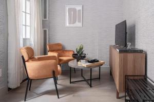 un soggiorno con 2 sedie, TV e tavolo di Apartment 256: Upper West Side a New York