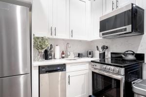 una cucina con armadietti bianchi ed elettrodomestici in acciaio inossidabile di Apartment 256: Upper West Side a New York