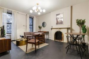- un salon avec une cheminée, une table et des chaises dans l'établissement Apartment 332: Hells Kitchen, à New York