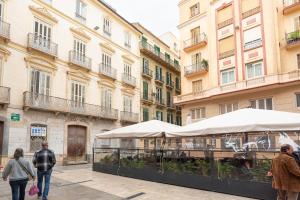 Gente caminando por una calle en una ciudad con edificios en Lazcano & old town by ELE Apartments, en Málaga