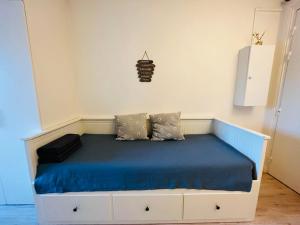 a bedroom with a bed with blue sheets and pillows at Dream Dwell Paris-Charming Studio superb location in 7th district Paris in Paris