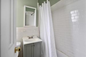 baño con lavabo y cortina de ducha blanca en Apartment 566: East Village, en Nueva York