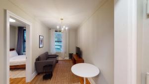 Cette chambre comprend un canapé, un lit et une table. dans l'établissement Apartment 549: Upper West Side, à New York