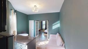 sala de estar con paredes azules y sofá blanco en Apartment 566: East Village, en Nueva York