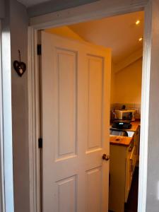 a white door leading into a kitchen with a counter at Entire ground floor town flat - Fully equipped and stunning. in Shrewsbury