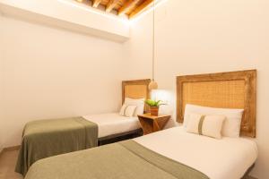 Habitación con 2 camas y mesa. en Lazcano & old town by ELE Apartments, en Málaga