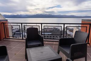 a balcony with chairs and a view of the water at Belgrano Decks II in San Carlos de Bariloche