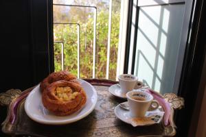 una mesa con dos platos de comida y dos tazas de café en Casale Delle Arti, en Mosciano SantʼAngelo