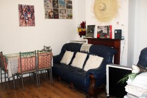 uma sala de estar com um sofá e uma mesa em cozy rooms in London Townhouse fast links to Central em Londres