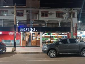 een zwarte truck geparkeerd voor een hotel bij Hotel La Gran Manzana in Puerto Iguazú